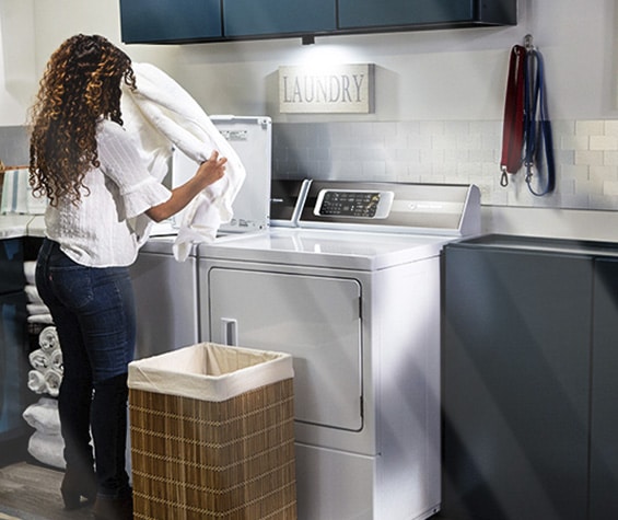 Illustration: woman using a speed queen top load washer in an OPL laundry room